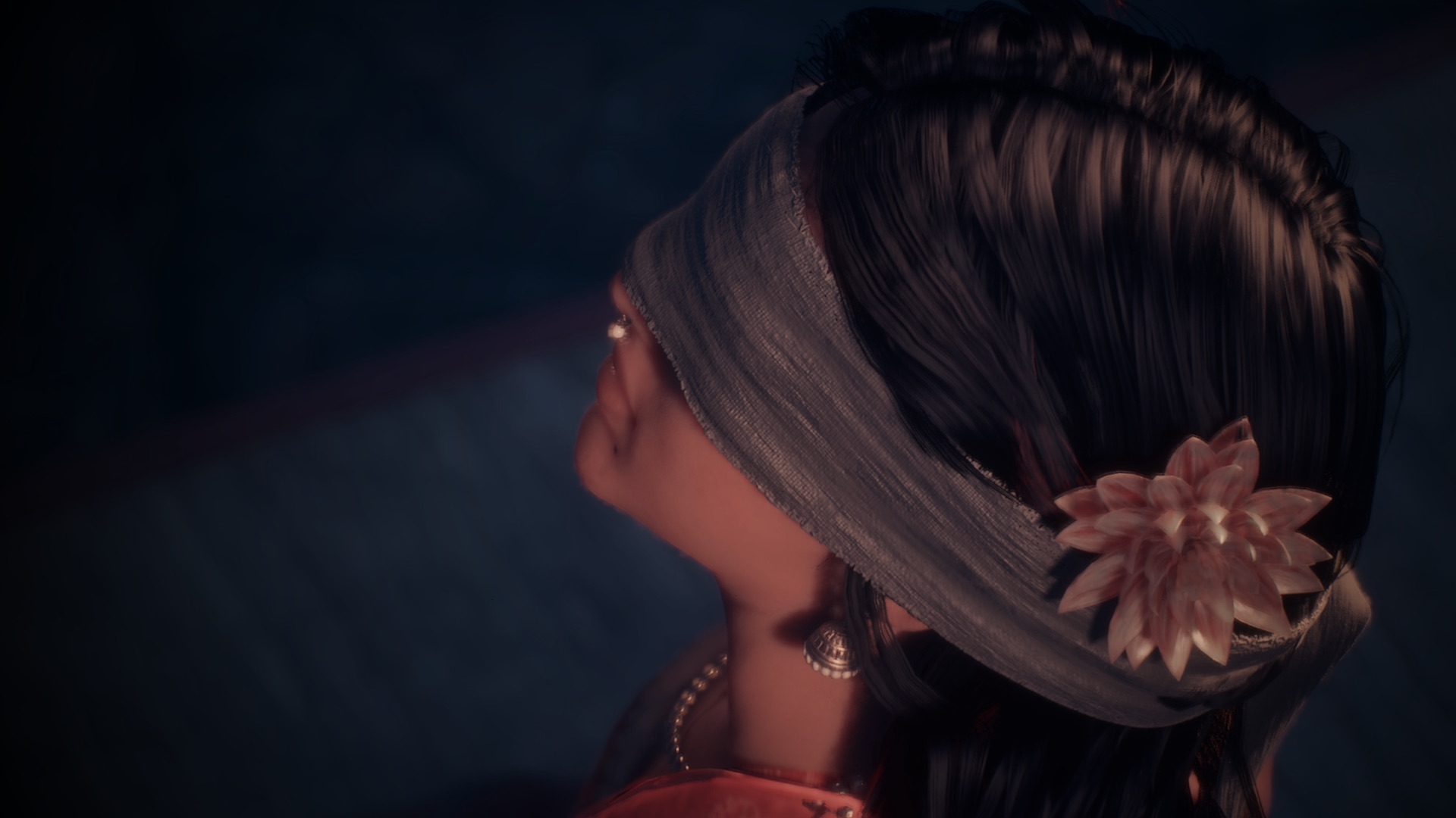 A blindfolded woman with a flower in her hair